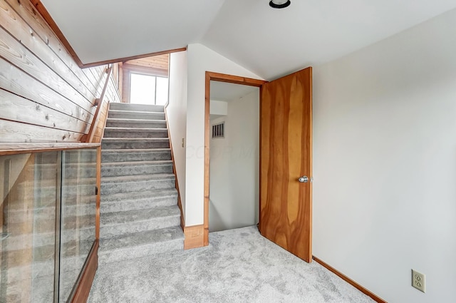 stairway with carpet flooring and lofted ceiling