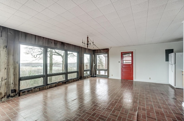 interior space featuring an inviting chandelier and wooden walls