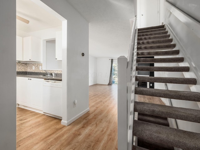 stairway with hardwood / wood-style flooring and sink