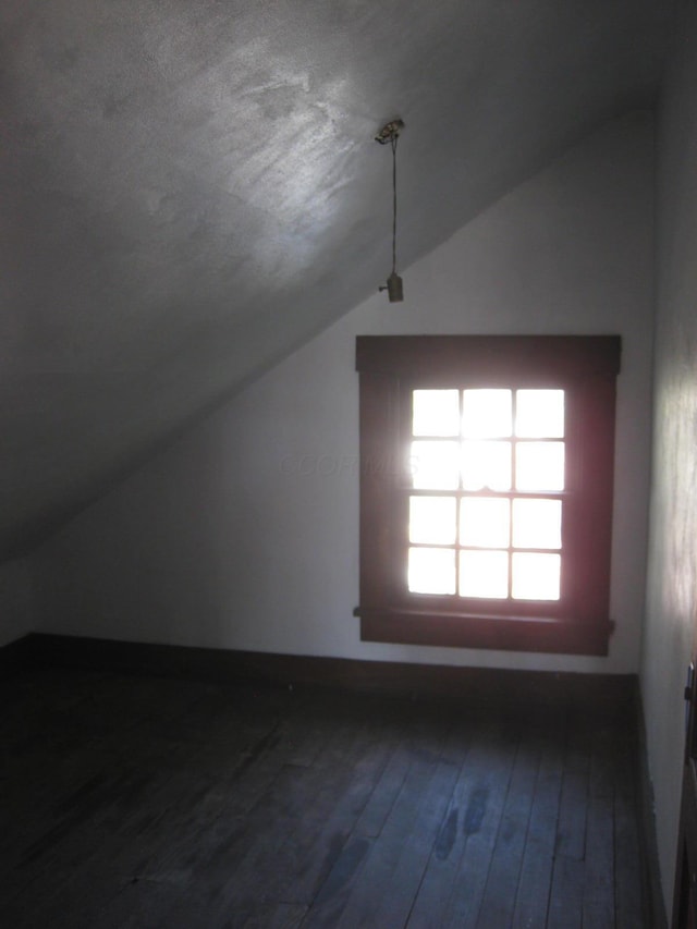 bonus room featuring a textured ceiling, hardwood / wood-style floors, and lofted ceiling