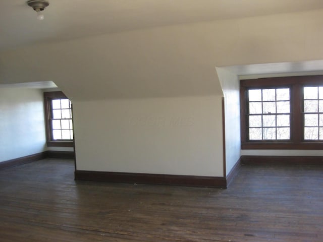 bonus room with dark hardwood / wood-style floors, vaulted ceiling, and a wealth of natural light