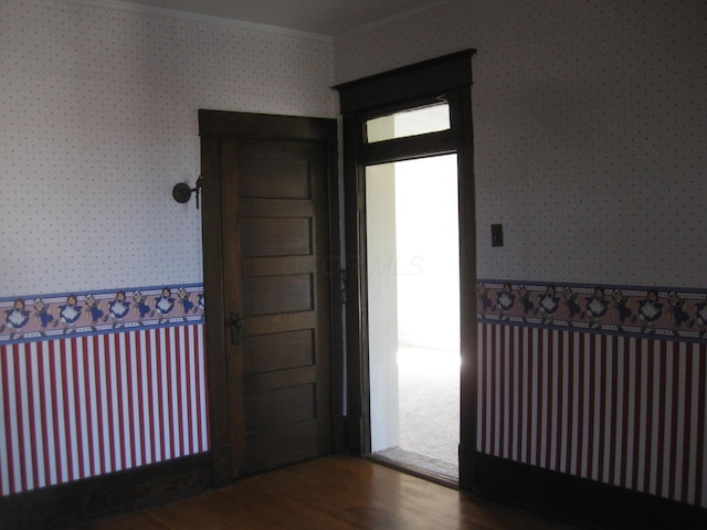 entrance foyer with dark wood-type flooring and crown molding