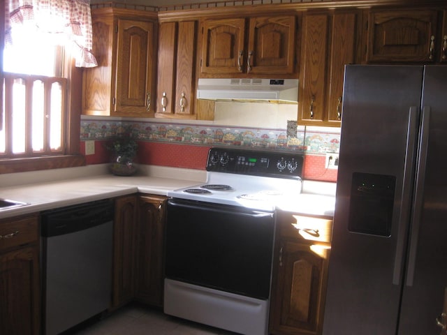 kitchen with backsplash, tile patterned floors, and appliances with stainless steel finishes