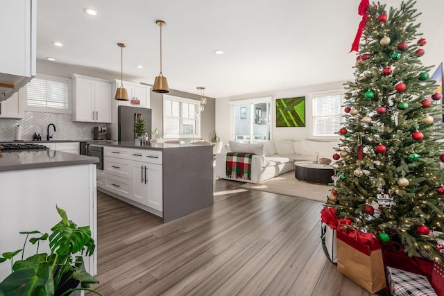 kitchen with pendant lighting, hardwood / wood-style flooring, white cabinetry, and a healthy amount of sunlight