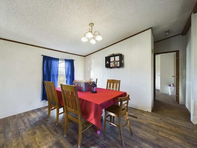 dining area with a chandelier, a textured ceiling, and dark hardwood / wood-style flooring