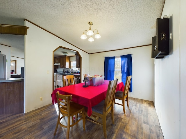 dining area featuring dark hardwood / wood-style flooring, ornamental molding, a textured ceiling, and a notable chandelier