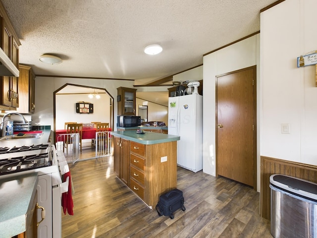 kitchen featuring dark hardwood / wood-style flooring, white appliances, a textured ceiling, vaulted ceiling, and a kitchen island