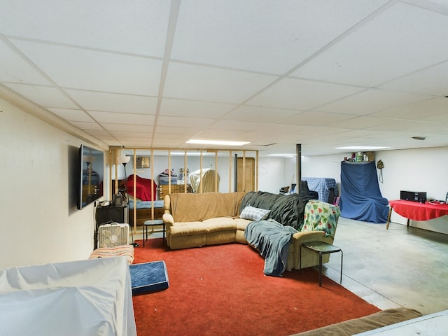 living room with a drop ceiling and concrete flooring