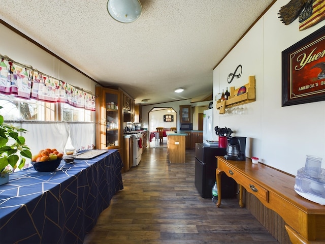 interior space with white gas range, tile counters, dark hardwood / wood-style flooring, and a textured ceiling