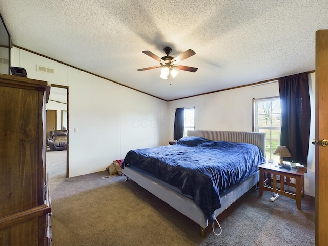 carpeted bedroom featuring ceiling fan, crown molding, and a textured ceiling