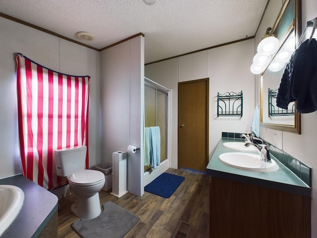 bathroom with an enclosed shower, ornamental molding, a textured ceiling, hardwood / wood-style floors, and radiator heating unit