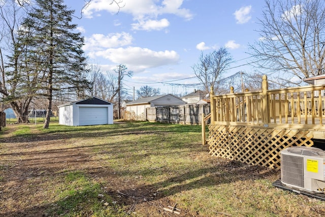 view of yard with an outbuilding, central AC, a garage, and a deck