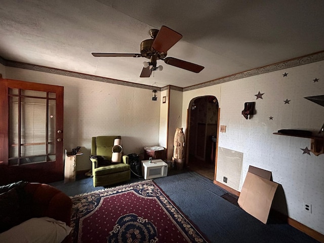 living room featuring ceiling fan and crown molding