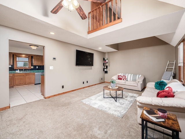 carpeted living room with a textured ceiling, ceiling fan, and sink