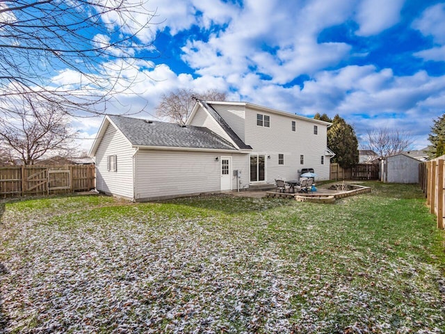 back of house with a lawn, a patio, and a storage shed