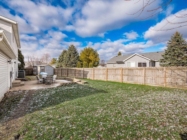 view of yard featuring a patio area, central AC unit, and a storage shed