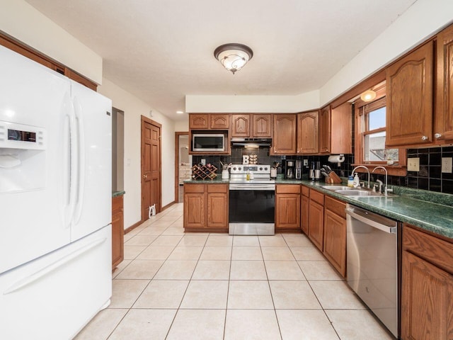 kitchen featuring decorative backsplash, sink, light tile patterned floors, and stainless steel appliances