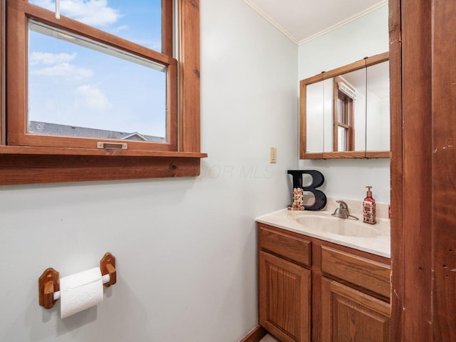 bathroom featuring plenty of natural light, ornamental molding, and vanity