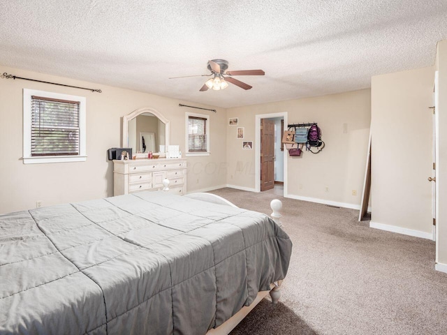 bedroom featuring ceiling fan, light carpet, and a textured ceiling