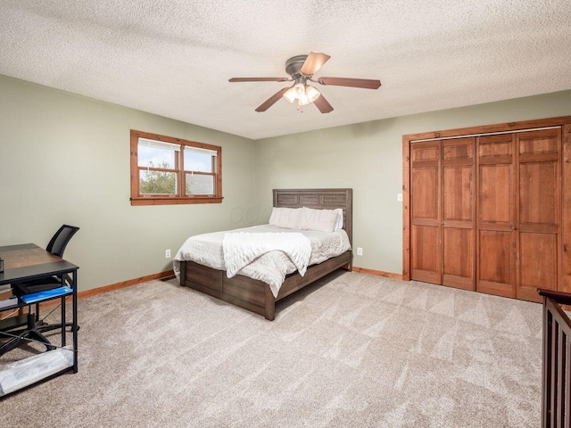 carpeted bedroom featuring ceiling fan, a textured ceiling, and a closet