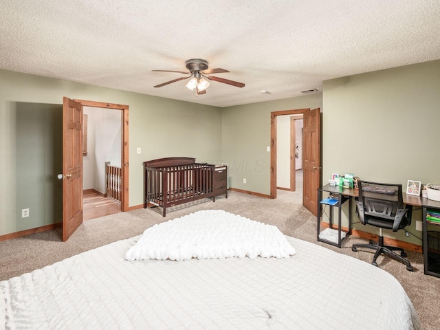 carpeted bedroom featuring ceiling fan and a textured ceiling