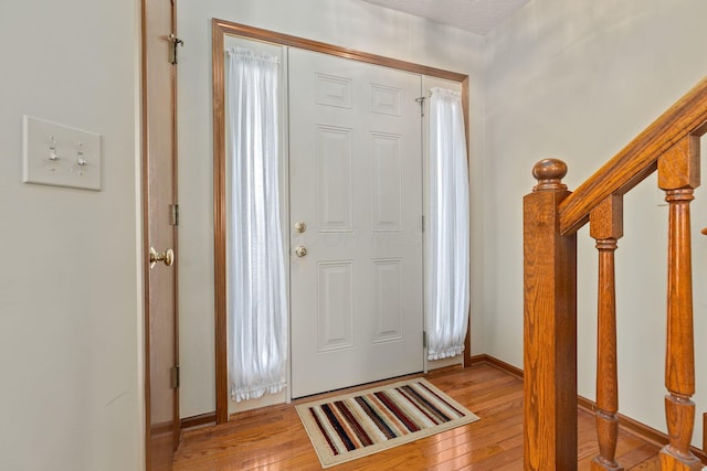 entrance foyer with light hardwood / wood-style flooring and a textured ceiling