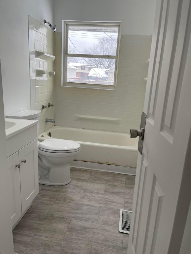 full bathroom featuring vanity, toilet, and tiled shower / bath combo