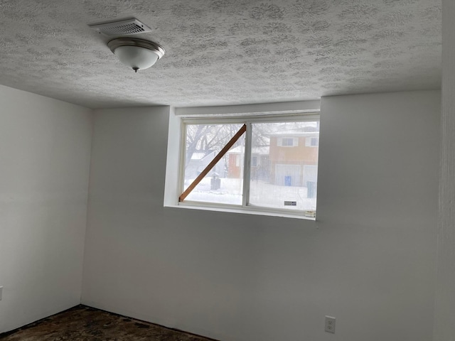 unfurnished room featuring a textured ceiling