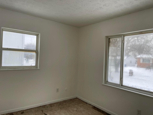 unfurnished room with a textured ceiling