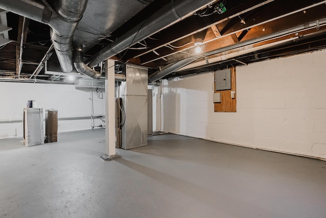 basement featuring electric panel and heating unit