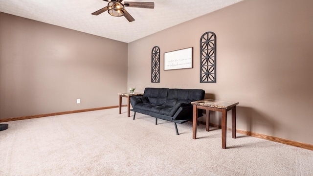 living area featuring a textured ceiling, carpet floors, and ceiling fan