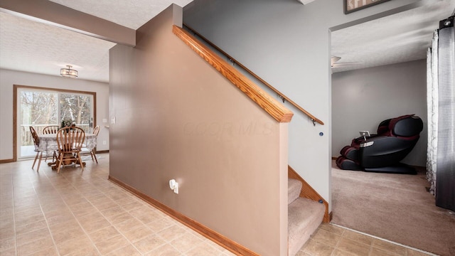 stairs with beamed ceiling, a textured ceiling, and carpet floors