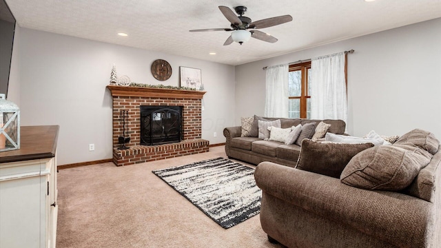 living room featuring a textured ceiling, light colored carpet, a brick fireplace, and ceiling fan