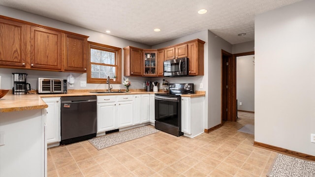 kitchen featuring a textured ceiling, stainless steel appliances, and sink