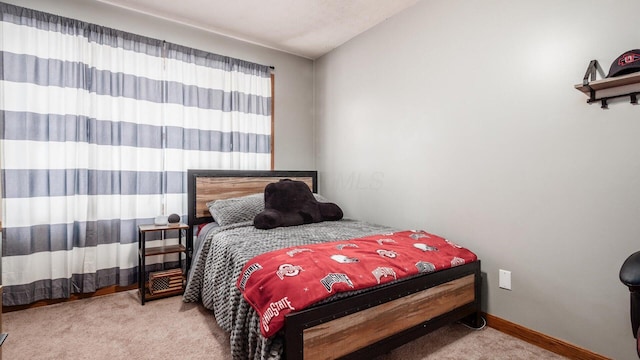 carpeted bedroom with lofted ceiling