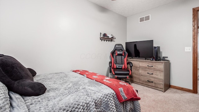 bedroom featuring light colored carpet and a textured ceiling