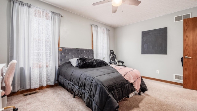 bedroom with multiple windows, ceiling fan, and light colored carpet