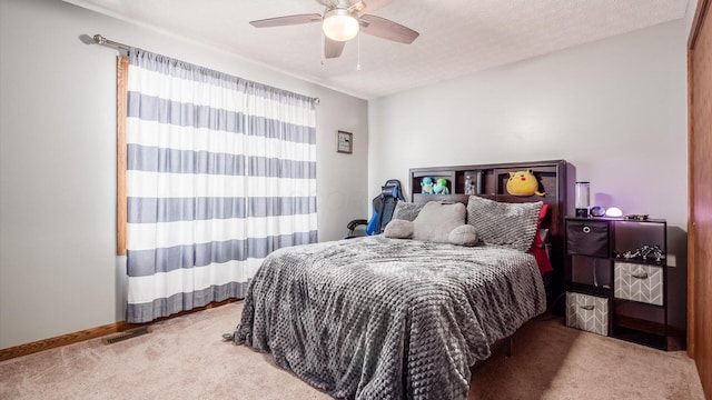 carpeted bedroom featuring a textured ceiling and ceiling fan