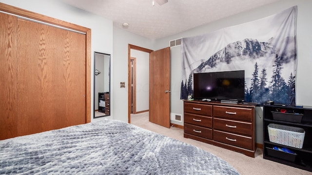 carpeted bedroom with a textured ceiling and a closet