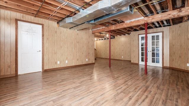 basement featuring wood-type flooring and wood walls