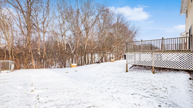 snowy yard featuring a wooden deck