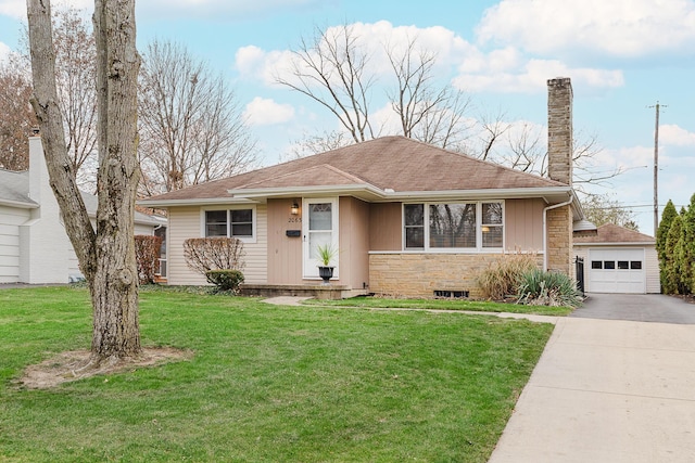 view of front of property with a garage, a front lawn, and an outdoor structure