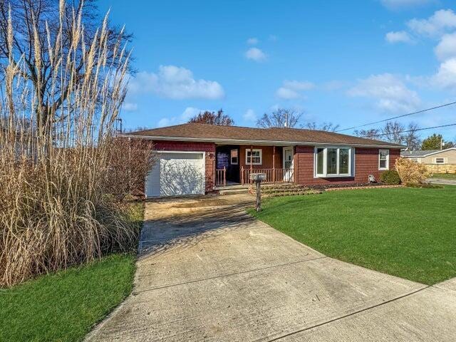 ranch-style house with covered porch, a front yard, and a garage