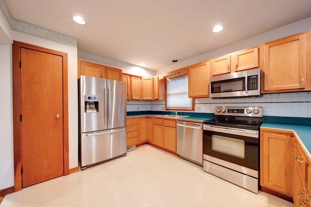 kitchen featuring decorative backsplash, light brown cabinets, stainless steel appliances, and sink