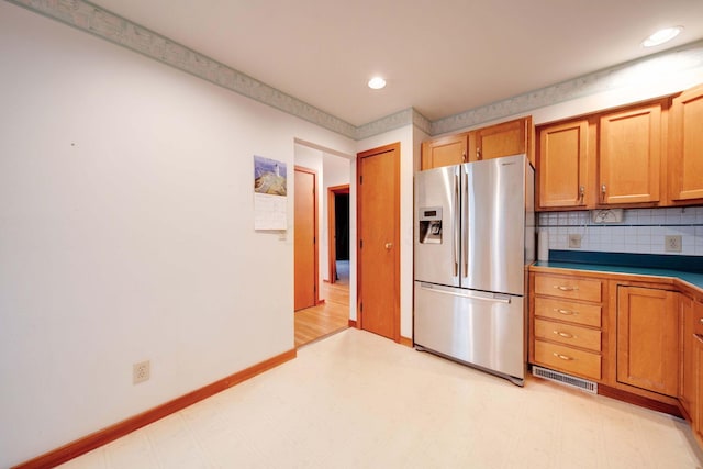 kitchen featuring tasteful backsplash and stainless steel fridge with ice dispenser