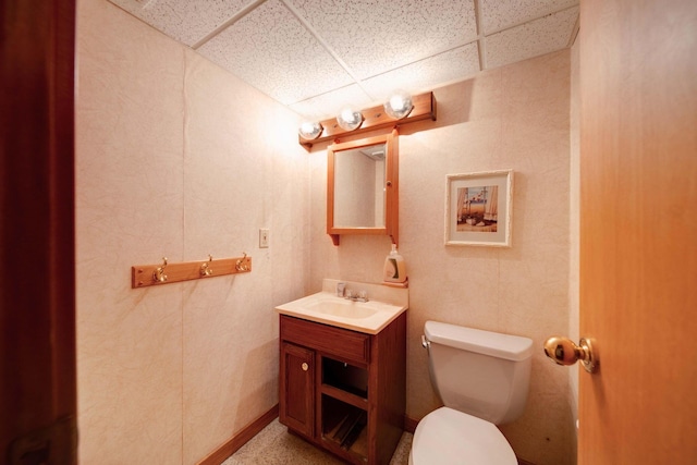 bathroom featuring a paneled ceiling, vanity, and toilet