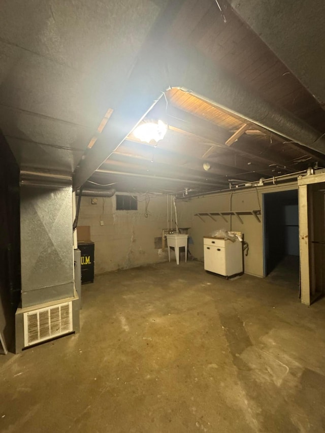 basement featuring sink and heating unit