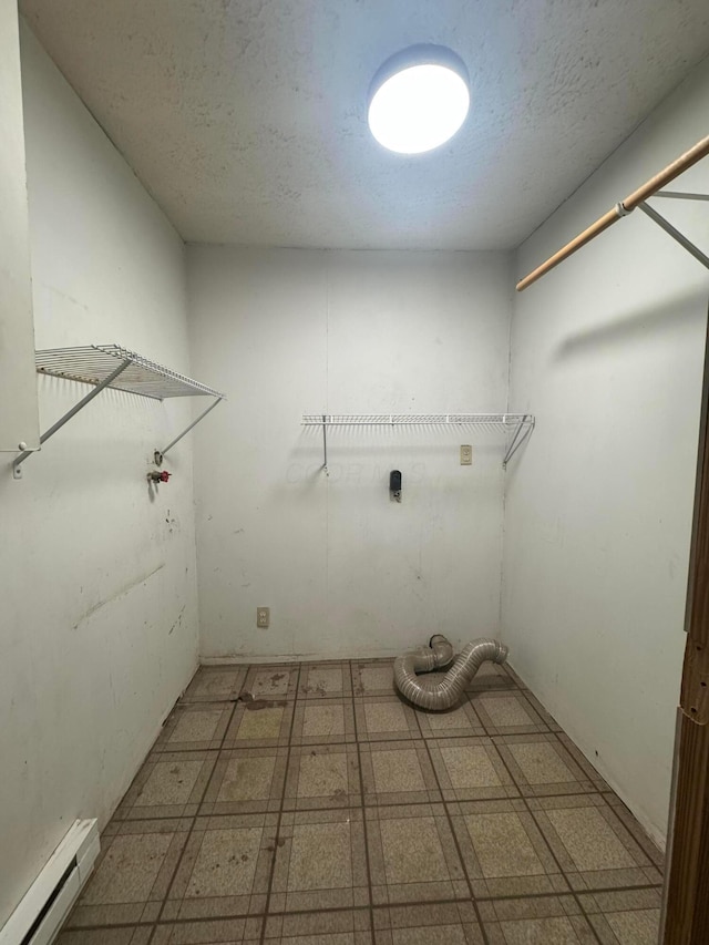 washroom featuring hookup for an electric dryer, a textured ceiling, and a baseboard heating unit