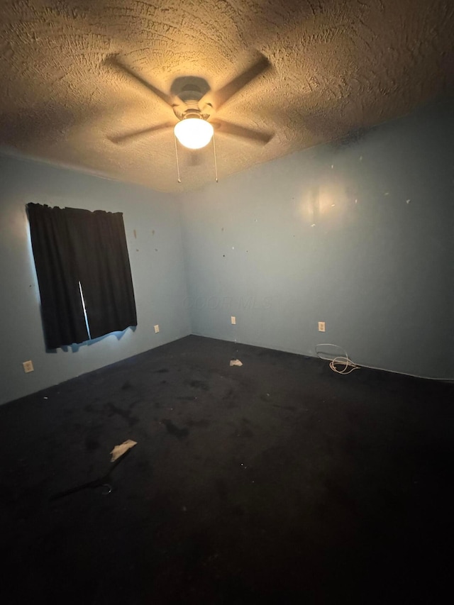 empty room featuring ceiling fan and a textured ceiling