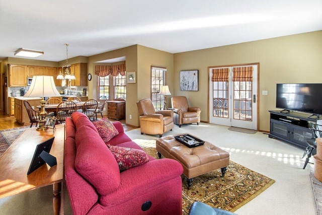 carpeted living room with a notable chandelier